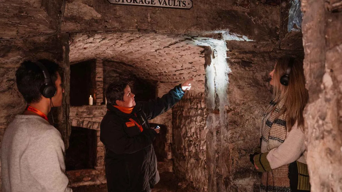 Visitor handling an excavated artefact in the Blair Street vaults on a small-group historic vaults tour in Edinburgh
