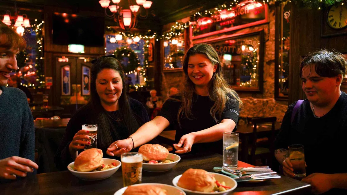 Small group tasting haggis at a Grassmarket pub on an Edinburgh Old and New Town food walking tour